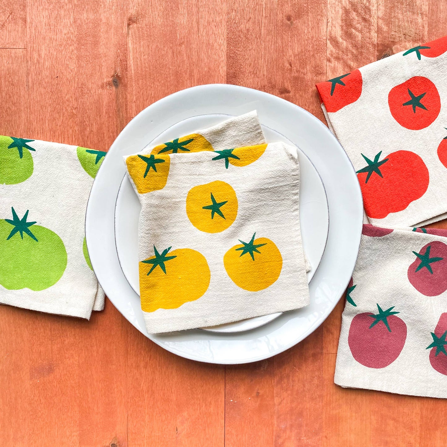 Napkins with tomato designs on a wooden surface