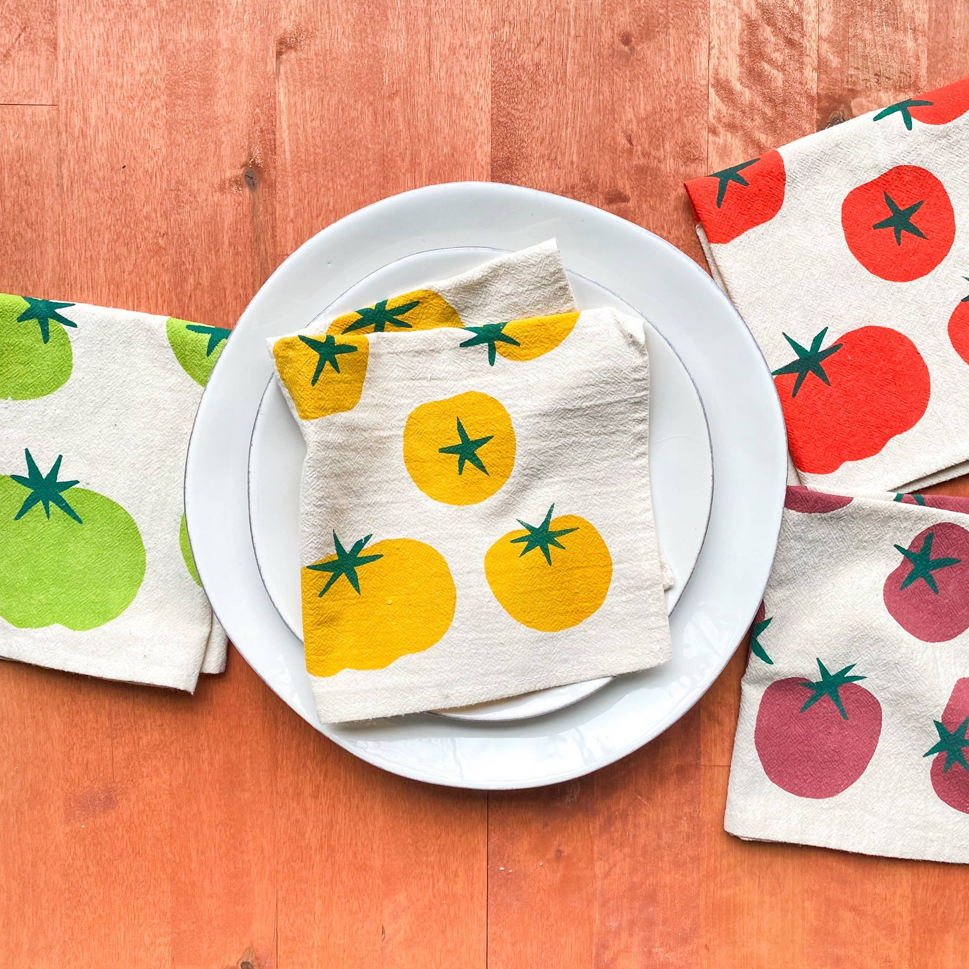 Napkins with tomato designs on a wooden surface
