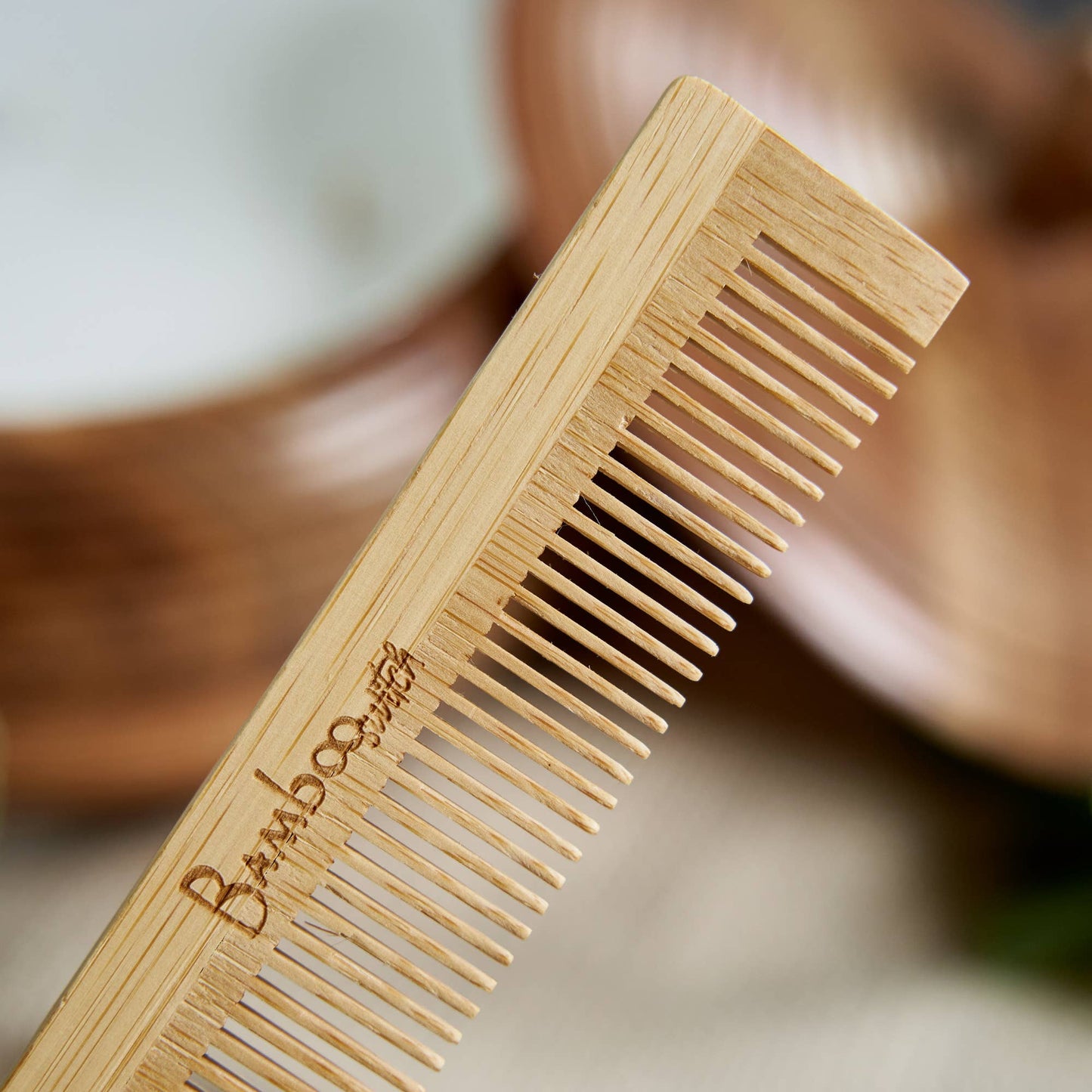 Bamboo comb with 'Bamboo' engraving on a blurred background