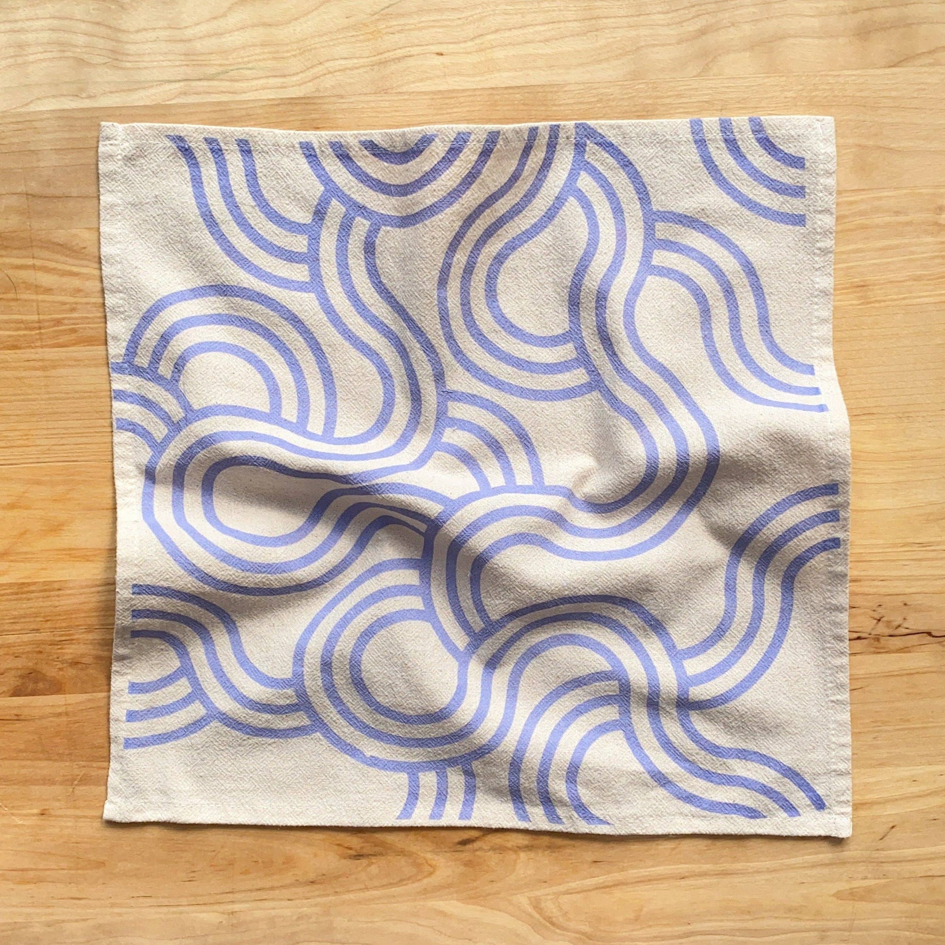 Fabric with blue wavy pattern on a wooden surface