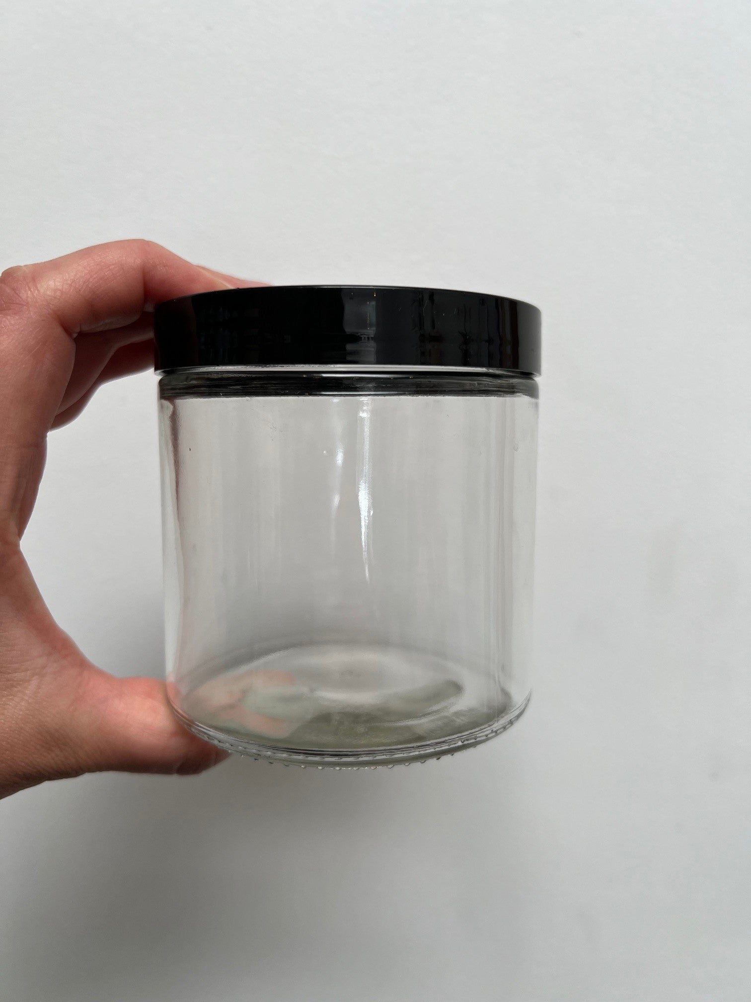 16 ounce clear glass jar with black plastic lid, shown as a container option