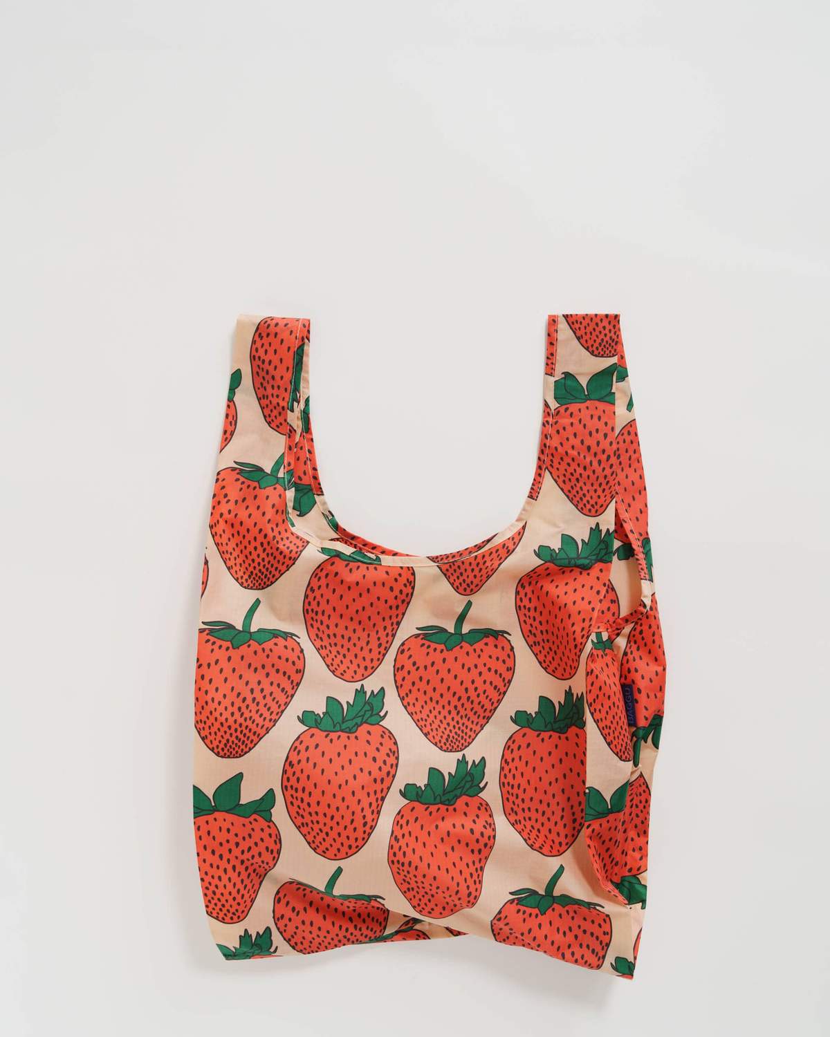 White background with standard size nylon bag laying flat to show pink and red strawberry pattern